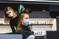 Master woman hairdresser in a medical mask dries the girl's hair with a hairdryer and combs after washing in a beauty Royalty Free Stock Photo