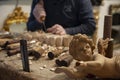 Master woodcarver at work. Wood shavings, gouges and chisels on the workbench. Angel wood carved in the foreground.. Royalty Free Stock Photo