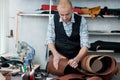 A master in the workshop, carefully examining the leather rolls