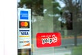 MasterCard, VISA, American Express, Discover payment options on a restaurant door