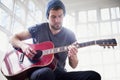 Mastering a new chord. a handsome young man playing a guitar at home. Royalty Free Stock Photo