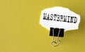 MASTERMIND - the word is printed on a white piece of paper on a yellow background