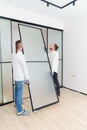 masters install sliding doors of wardrobe made of metal and glass. Royalty Free Stock Photo