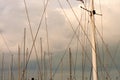 Masts and many ropes of sailing boats standing in harbor. Graphic image with oblique and vertical lines.