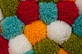 Mat of pompons made from multi-colored handmade yarn Royalty Free Stock Photo