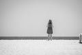 A woman contemplates the horizon on the sand