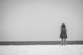 A woman contemplates the horizon on the sand