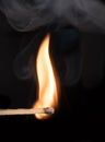Match bursting into flame with smoke against black background Royalty Free Stock Photo