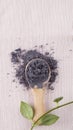 Matcha blue tea powder in wood spoon on pink background