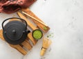 Matcha green organic tea powder with iron cast kettle with bamboo whisk and spoon on wooden tray on white Royalty Free Stock Photo