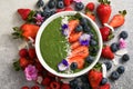 Matcha green tea breakfast superfoods smoothies bowl topped with strawberries, blueberries, coconut flakes Overhead, top view,