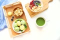 Matcha green tea, breakfast top view white background. oatmeal with berries, toasts on a wooden tray, nuts, coffee Royalty Free Stock Photo