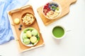 Matcha green tea, breakfast top view white background. oatmeal with berries, toasts on a wooden tray, nuts, coffee Royalty Free Stock Photo