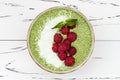 Matcha green tea chia seed pudding bowl, vegan dessert with raspberry and coconut milk. Overhead, top view, flat lay. Royalty Free Stock Photo