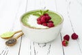 Matcha green tea chia seed pudding bowl, vegan dessert with raspberry and coconut milk. Overhead, top view, flat lay.