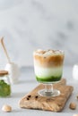 Matcha green tea espresso, matcha green tea with milk, ice and coffee on a wooden board. Layered matcha drink. Fresh summer drink Royalty Free Stock Photo