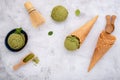 Matcha green tea ice cream with waffle cone and mint leaves setup on white stone background . Summer and Sweet menu concept