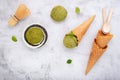 Matcha green tea ice cream with waffle cone and mint leaves setup on white stone background . Summer and Sweet menu concept