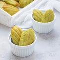 Matcha green tea madeleines on table and in wooden tray, square Royalty Free Stock Photo