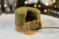 MATCHA GREEN TEA MOLTEN LAVA CAKE SERVED ON WHITE PLATE AND CHRISTMAS BOKEH LIGHTS BACKGROUND Royalty Free Stock Photo