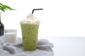 Matcha green tea in a plastic glass on top whipping cream and milk glass on wooden and jar of plants isolated white background, Royalty Free Stock Photo