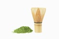 Matcha, green tea powder and bamboo whisk on white