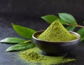 Matcha green tea powder in bowl, black table, green matcha leaves Royalty Free Stock Photo