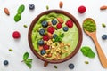 Matcha green tea smoothie bowl with fresh fruits, berries, nuts, seeds and granola with a spoon for healthy breakfast Royalty Free Stock Photo