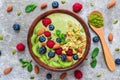 Matcha green tea smoothie bowl with fresh fruits, berries, nuts, seeds and granola with a spoon for healthy breakfast Royalty Free Stock Photo