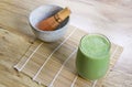 Matcha Green Tea Smoothie with Stone Bowl and wooden whisk on bamboo mat on table Royalty Free Stock Photo