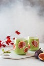 Matcha green vegan smoothie with chia seeds and figs in glasses on white background. Autumn detox recipe, superfoods, healthy Royalty Free Stock Photo