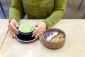 Matcha latte Cup of green tea and smoothie bowl of raw food on the table and a woman ready to drink Royalty Free Stock Photo