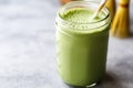 a matcha latte in a mason jar with a paper straw