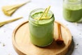 matcha overnight oats in a cylindrical glass, bamboo mat under