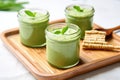 matcha overnight oats in a cylindrical glass, bamboo mat under