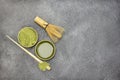 Matcha tea in a bowl. Green Matcha tea powder in a wooden bowl. Bamboo whisk and spoon on the table Royalty Free Stock Photo