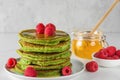 Matcha tea green pancakes. Pile of homemade pancakes with fresh raspberries and honey. healthy breakfast dessert Royalty Free Stock Photo