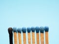 Matches against a blue background, one burned out Royalty Free Stock Photo