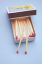 Matches in an open box on a pastel blue table Royalty Free Stock Photo