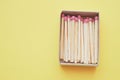 Matches in an open box on a yellow paper table. Copy space Royalty Free Stock Photo