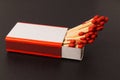 Matches in an open matchbox on a black background. A blank, white label on the matchbox Royalty Free Stock Photo