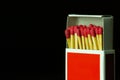 Matches stick in red paper box on black background. Royalty Free Stock Photo