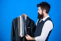 Matching necktie with outfit. Man bearded hipster hold neckties and formal suit. Guy choosing necktie. Perfect necktie