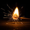 A matchstick ignites in the dark, producing a bright flame and scattering sparks. The Royalty Free Stock Photo