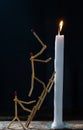 Matchsticks in form of a man lighting a candle, matchstick man lighting a candle. Royalty Free Stock Photo