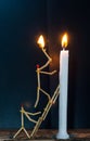Matchsticks in form of a man lighting a candle, matchstick man lighting a candle. Royalty Free Stock Photo