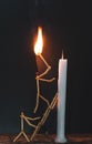 Matchsticks in form of a man lighting a candle, matchstick man lighting a candle. Royalty Free Stock Photo