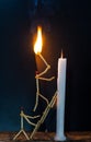 Matchsticks in form of a man lighting a candle, matchstick man lighting a candle. Royalty Free Stock Photo