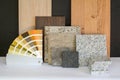 Material collage with natural stone, tiles, wooden parquet floor and color card for renovation of an apartment building