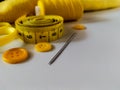 A collection of yellow sewing accessories on a white background Royalty Free Stock Photo